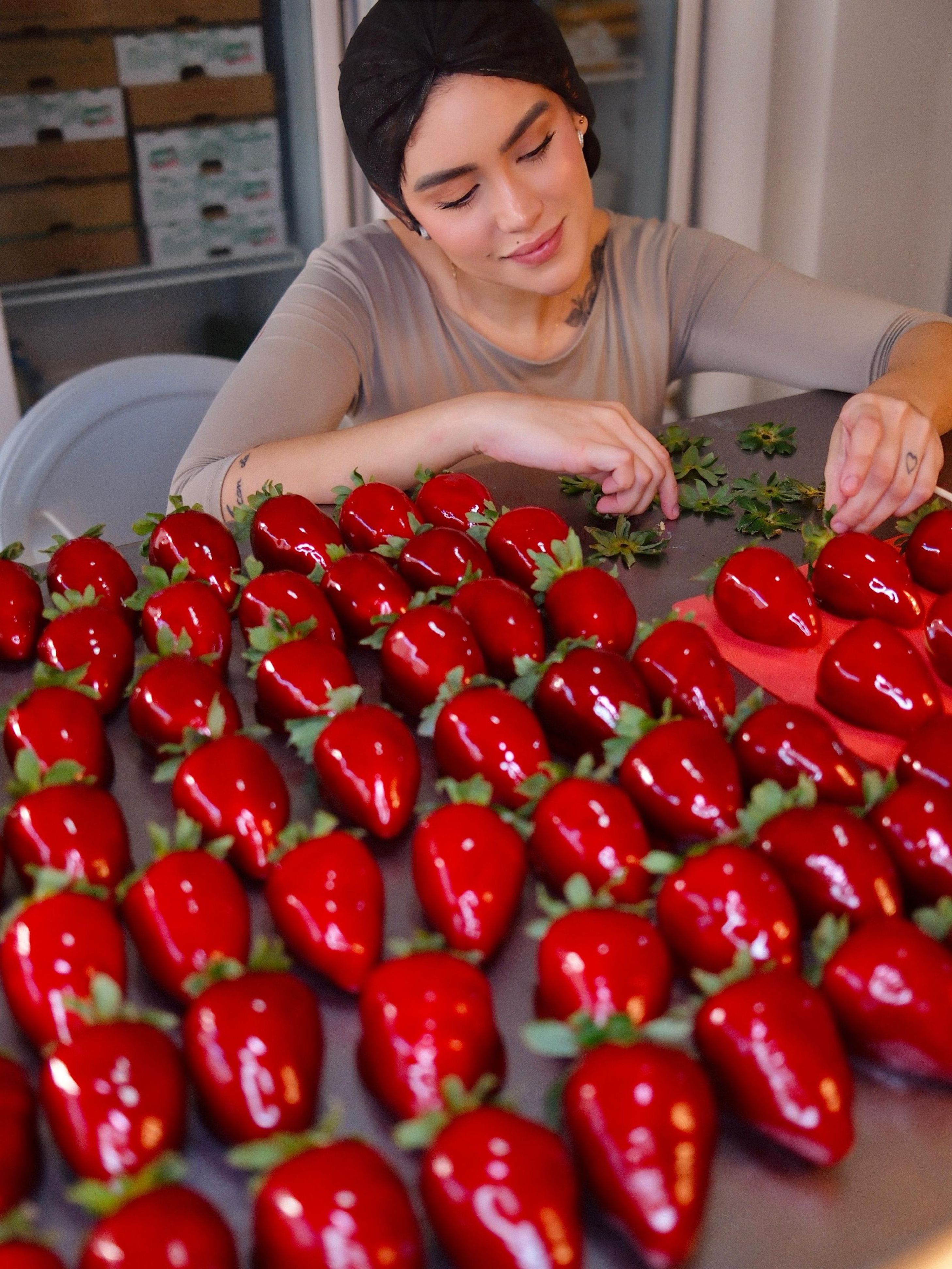 Millena com caixa grande de morangos do amor na confeitaria