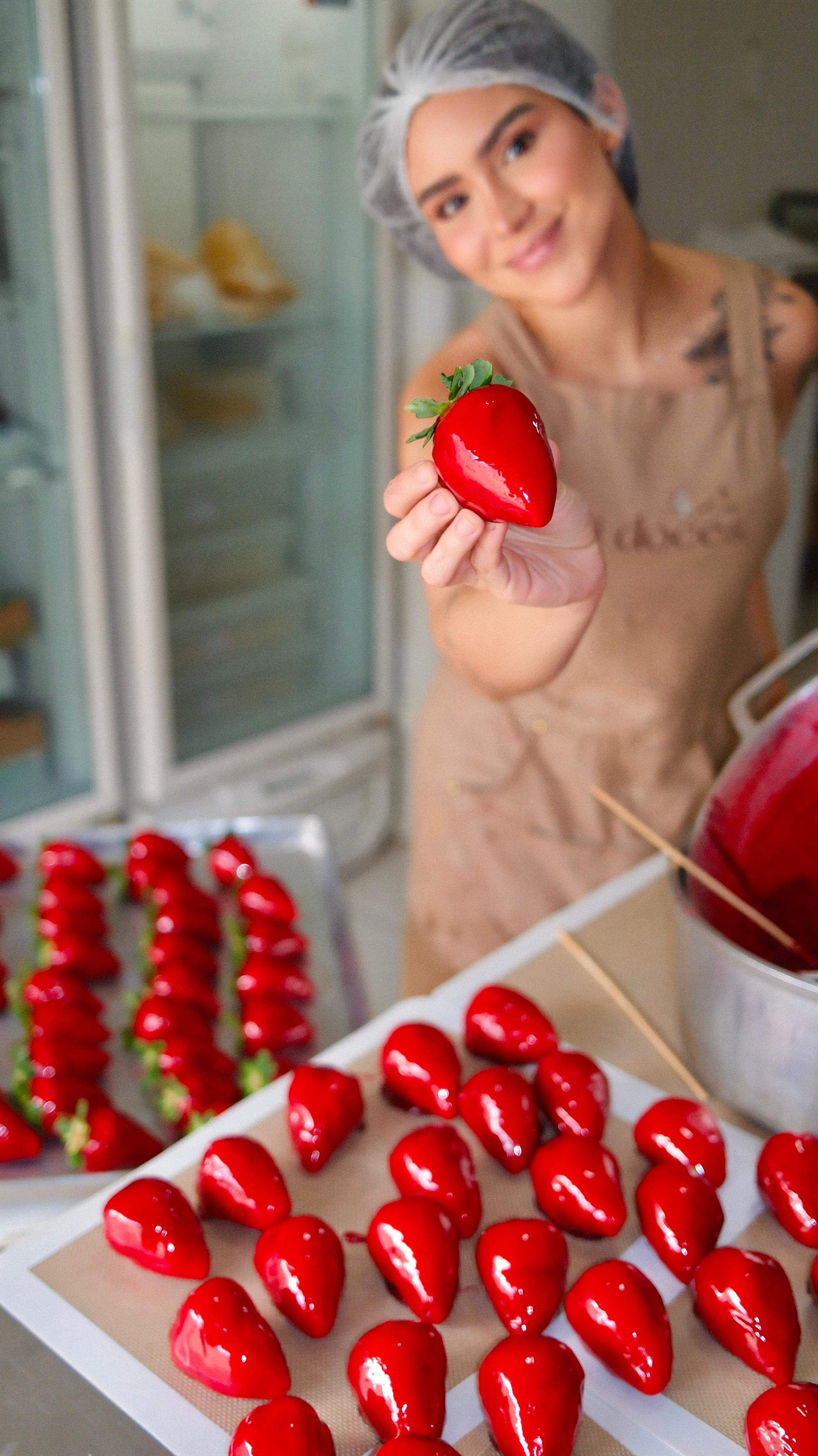 Millena segurando morango do amor perfeito